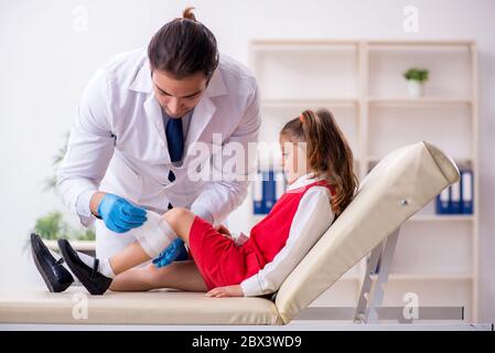 Piccola ragazza che visita giovane medico Foto Stock