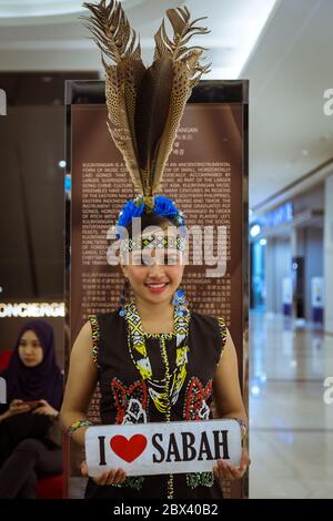 Kota Kinabalu, Sabah , Malesia - 22 maggio 2017 : una bella signora Murut in costume tradizionale e tenendo il segno di amore SABAH, Murut è tra i più grandi Foto Stock