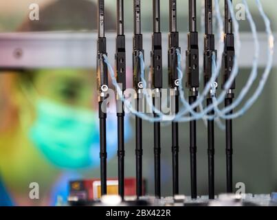 Potsdam, Germania. 02 giugno 2020. Claudia Fröschke, Assistente medico-tecnico di laboratorio (MTLA) presso l'ospedale Ernst von Bergmann, osserva la nuova macchina in laboratorio durante il test automatico di striscio della corona PCR. La macchina è in grado di analizzare 96 test contemporaneamente. Il test PCR (PCR sta per reazione a catena della polimerasi) è un metodo complesso di rilevazione del virus in cui il genoma virale viene amplificato in laboratorio in modo che l'infezione possa essere rilevata. L'ospedale Ernst von Bergmann poteva analizzare fino a 470 test al giorno. Credit: Soeren Stache/dpa-Zentralbild/ZB/dpa/Alamy Live News Foto Stock