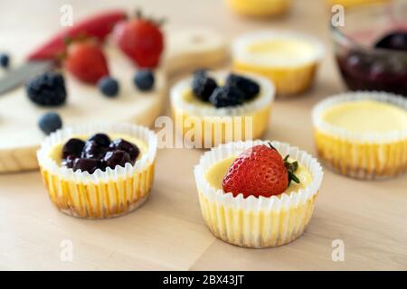 Mini cheesecake decorata con mirtillo, mora e fragola Foto Stock