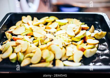Torta di mele per la produzione a mano da donna. Primo piano. Impasto messo sulle mele Foto Stock