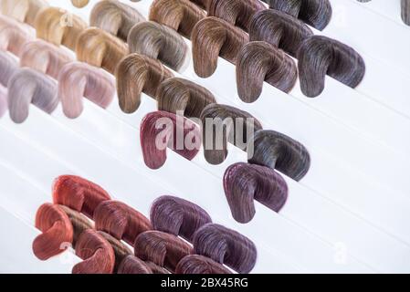 Tabella dei colori dei capelli. Tavolozza di campioni di capelli colorati e brillanti. Catalogo per la selezione in un salone di bellezza Foto Stock
