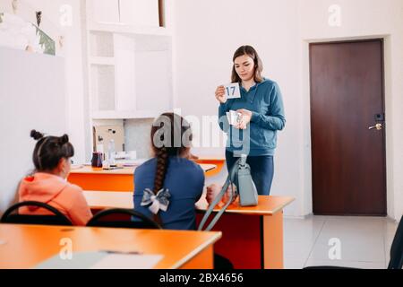 L'insegnante insegna ai bambini in classe esibisce una piccola tavola Foto Stock