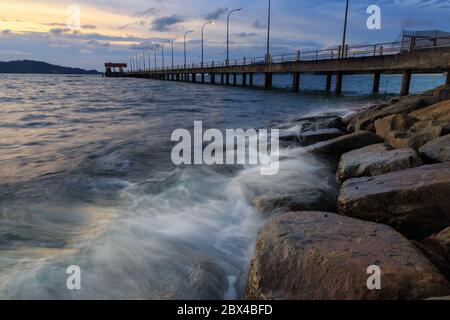 Scenario del tramonto del molo a Kota Kinabalau, Sabah in soft focus, sfocatura del movimento a causa della lunga esposizione Foto Stock