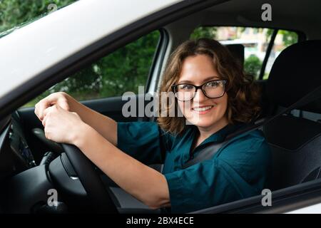 Donna conducente guida un'auto Foto Stock