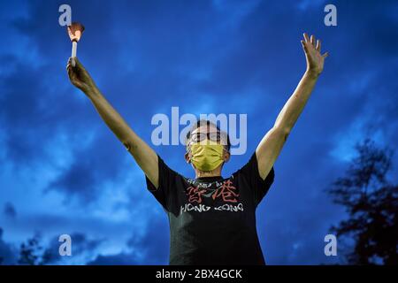 Hong Kong, Cina. 04giugno 2020. Un uomo tiene una luce a lume di candela mentre mostra il segno delle 5 richieste durante il 31° anniversario del massacro di Tiananmen. Migliaia di persone si sono riunite per la veglia commemorativa annuale nel Victoria Park per celebrare il massacro di Piazza Tiananmen del 1989 nonostante un divieto della polizia che cita le restrizioni di allontanamento sociale del coronavirus. Credit: SOPA Images Limited/Alamy Live News Foto Stock