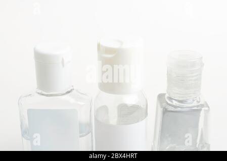 Una confezione di tre flaconi dispenser generici in plastica per igienizzatore manuale trasparente tascabili su fondo bianco. Foto Stock