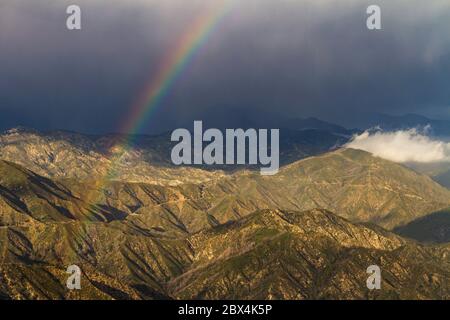 Un arcobaleno attraversa le nuvole delle montagne di San Gabriel, nella California meridionale Foto Stock