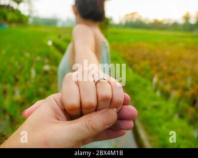 primo piano uomo di mani di coppia che tiene felice mano di fiance con anello di impegno di diamante sul suo dito dopo la proposta di matrimonio a tropicale bella e romantica Foto Stock