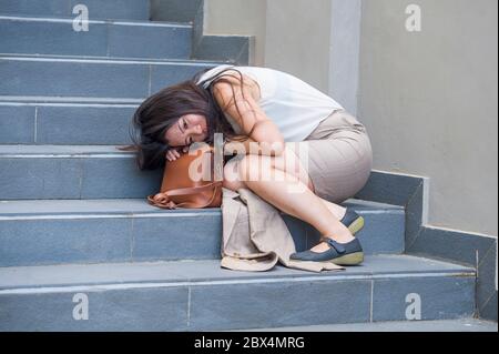 Giovane depressa e disperata donna d'affari asiatica coreana che piange da sola seduta su una scala di strada che soffre di stress e crisi di depressione essere vittima Foto Stock