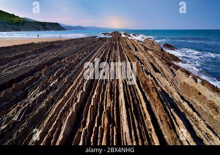 Vista ravvicinata delle linee rocciose che si dirigano verso l'oceano presso la spiaggia a bassa marea Foto Stock