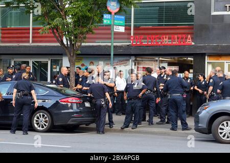 New York, New York. 3 giugno 2020. Diverse dozzine di detective della NYPD socializzano all'esterno di un negozio di pizza da 99 cent a Greenwich Village non a distanza sociale, non indossando maschere come richiesto dall'Ordine Esecutivo 202.17 rilasciato dal Governatore dello Stato di New York durante la pandemia del coronavirus COVID-19. Foto Stock