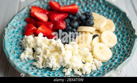 Sana colazione estiva. Formaggio di cottage con fragola mirtillo banana e miele. La colazione era bellissima Foto Stock