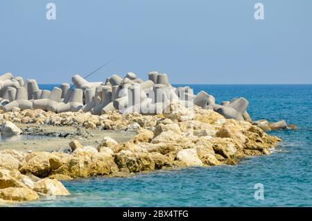 Blocchi di acqua di rottura in calcestruzzo sulla costa meridionale di Cipro nel Mar Mediterraneo. Foto Stock