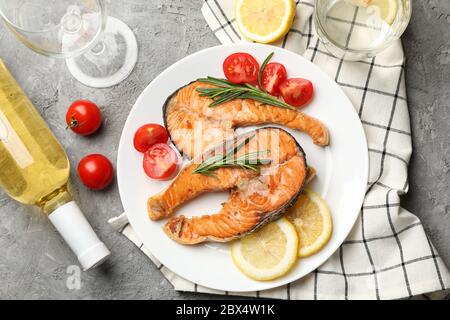 Composizione con gustoso salmone grigliato su sfondo grigio, vista dall'alto Foto Stock