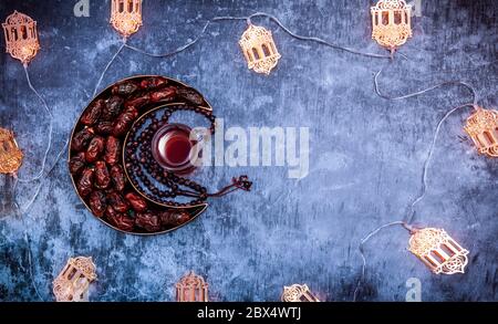 Immagine decorazione Ramadan e Eid, date in un piatto a forma di luna con tè turco e tashbi Islamic Iftar e Eid al Adha concetto di sfondo Foto Stock