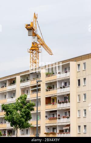 Heidenau, Germania. 04giugno 2020. Una gru si trova dietro un edificio residenziale a Heidenau, in Sassonia, con il suo lungo braccio. Dietro la casa, l'edilizia sociale viene demolita, anche se è necessaria per il mercato immobiliare nella conurbazione intorno alla capitale di stato Dresda. Credit: Daniel Schäfer/dpa-Zentralbild/ZB/dpa/Alamy Live News Foto Stock