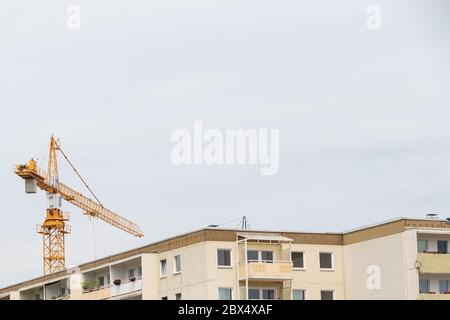 Heidenau, Germania. 04giugno 2020. Una gru si trova dietro un edificio residenziale a Heidenau, in Sassonia, con il suo lungo braccio. Dietro la casa, l'edilizia sociale viene demolita, anche se è necessaria per il mercato immobiliare nella conurbazione intorno alla capitale di stato Dresda. Credit: Daniel Schäfer/dpa-Zentralbild/ZB/dpa/Alamy Live News Foto Stock