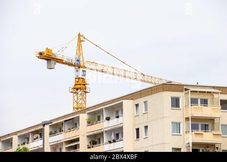 Heidenau, Germania. 04giugno 2020. Una gru si trova dietro un edificio residenziale a Heidenau, in Sassonia, con il suo lungo braccio. Dietro la casa, l'edilizia sociale viene demolita, anche se è necessaria per il mercato immobiliare nella conurbazione intorno alla capitale di stato Dresda. Credit: Daniel Schäfer/dpa-Zentralbild/ZB/dpa/Alamy Live News Foto Stock