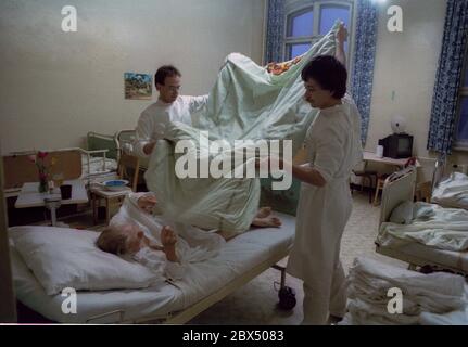 Berlino / Prenzlauer Berg / Salute / DDR / 3 / 1990 Prenzlauer Berg Hospital. Donna anziana in camera a 8 letti. Sul rione c'era un medico e un obiettore coscienzioso (soldato di costruzione). // anziani / cura / anziani / morte / *** Città di Roma *** Germania Est / Germania Comunista / Ospedale sanitario a Prenzlauer Berg, quartiere di Berlino Est. [traduzione automatizzata] Foto Stock