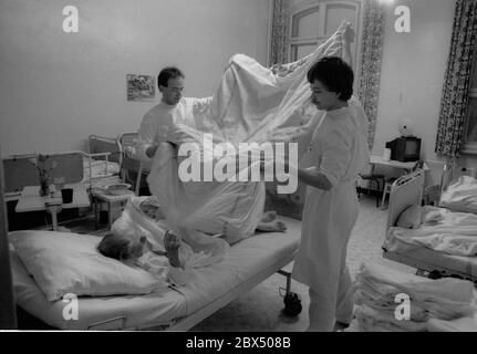 Berlino / Prenzlauer Berg / Salute / DDR / 3 / 1990 Prenzlauer Berg Hospital. Donna anziana in camera a 5 letti. Sul rione c'era un medico e un obiettore coscienzioso (soldato di costruzione). // anziani / cura / anziani / morte / [traduzione automatizzata] Foto Stock