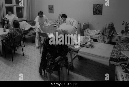 Berlino / Prenzlauer Berg / Salute / GDR / 3 / 1990 Vecchia donna in ospedale Prenzlauer Berg, reparto per pazienti cronicamente malati. La camera dispone di 8 letti. Infermieri. // anziani / cura / anziani / *** Città *** Germania Est / Germania Comunista / Ospedale sanitario a Prenzlauer Berg, quartiere di Berlino Est. [traduzione automatizzata] Foto Stock