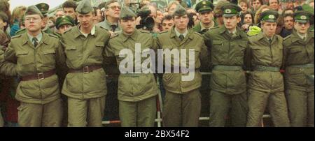 Berlino-Città / Mitte / Muro di Berlino 12.11.1989 Potsdamer Platz: C'è un vuoto nel Muro, la gente viene da Berlino Est e Ovest. L'unità delle guardie di frontiera della RDT con i loro Kalashnikov non spaventa più nessuno. Appartengono all'unità STASI di Feliks Dscherschinski. Dopo il fondatore del servizio segreto sovietico Cheka. // unificazione / fine del Muro / DDR / Esercito popolare / Guardia di frontiera / Storia / Storia del comunismo / Comunismo [traduzione automatizzata] Foto Stock