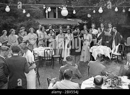 Gli studenti di musica americana cantano in giardino sotto la direzione del professor Tresskell della Columbia University. In onore degli studenti di musica americana della Columbia University New York, si è tenuta una reception presso la Carl Schurz Association, al 7° Victoriastrasse. Foto Stock