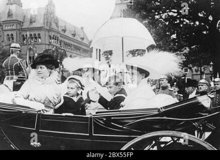 La celebrazione dell'anniversario del Reggimento Fusilier n° 90 a Rostock è seguita dalla Principessa della Corona Cecilie (centro), dai suoi due figli maggiori e dalla madre, la Granduchessa di Meclemburgo-Schwerin (a sinistra) nella sua carrozza durante la sfilata delle truppe. Foto Stock