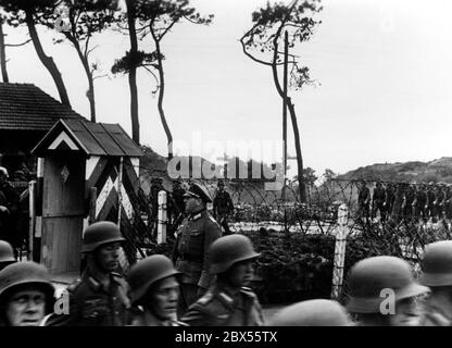 Graue Kolonnen (colonne grigie) in Francia. I soldati tedeschi stanno invadendo la Francia. Al centro della foto sono state erette recinzioni in filo spinato. Foto Stock