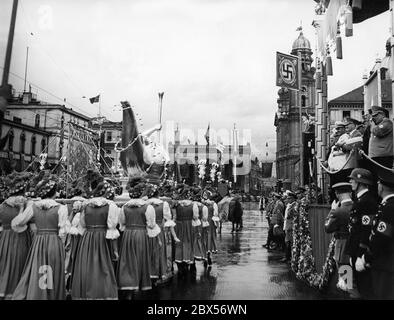 Il giorno dell'arte tedesca si svolge a Monaco una sfilata. Qui il gruppo Sudetenland in costume popolare si trova davanti alla tribuna VIP con una scultura e una mappa sull'Odeonsplatz di fronte alla Feldherrnhalle e alla Theatinerkirche. Su questa stalla da sinistra a destra: Dino Alfieri, Adolf Hitler, Heinrich Hoffmann, che sta scattando fotografie. Sullo sfondo, Joseph Goebbels e Adolf Wagner. Foto Stock