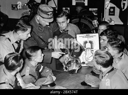 I membri della Gioventù Hitler durante una lezione teorica sulla costruzione tecnica di un motore. Nella classe di NSKK Lichterfelde tutti ascoltano l'istruttore che usa un motore smontato per spiegare la struttura. Sul tavolo in background c'è una moto DKW SB 200A. Foto Stock