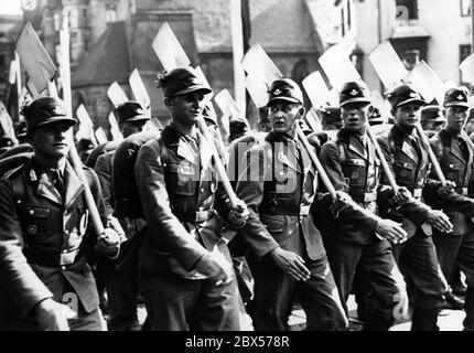 Gli uomini del servizio laburista Reich marciano per le strade di Norimberga con le loro picche, dopo la chiamata del gruppo al Congresso del Partito Reich sul campo di Zeppelin. Foto Stock