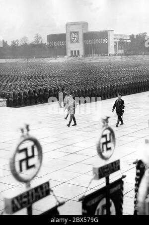 Adolf Hitler (fronte), Viktor Lutze (sinistra) e Heinrich Himmler (destra) marciano dalla piattaforma della Luitpold Arena per deporre la corona al memoriale di Ehrenhalle, durante la grande chiamata di rullo del SA, SS, NSKK e NSFK. Sullo sfondo è la Luitpoldhalle. Foto Stock