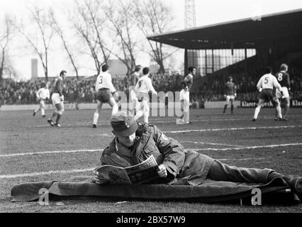 Un paramedico legge una rivista sportiva e non presta attenzione alla partita di calcio, Bundesliga, stagione 1969/1970, FC Schalke 04 contro Rot-Weiss Oberhausen 2: 2 Stadion Glueckaufkampfbahn Foto Stock