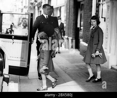 Elizabeth II e sua sorella Margaret Rose lasciano il Bath Club su dover Street a Westminster. Entrambi hanno ricevuto un certificato salvavita. Foto Stock