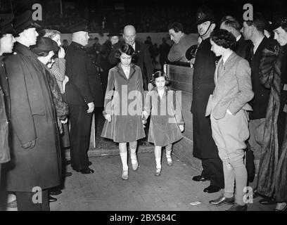 Elizabeth II e sua sorella Margaret Rose (a destra) sulla loro strada per la cerimonia di premiazione del National Pony Show nella Sala dell'Agricoltura a Islington, Londra Foto Stock