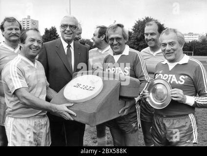 La squadra del FC Schmiere e una squadra del parlamento di Stato bavarese si incontrano in una partita di beneficenza. Davanti a sinistra: Il capitano della squadra del parlamento tedesco Hans Kollo, presidente del Parlamento di Stato Franz Heubl, Dieter Hildebrandt e Sammy Drechsel. Heubl ha dato ai vincitori un piatto di peltro con il motivo del parlamento di Stato (Landtag). Il ricavato è stato devoluto all'associazione no profit Telefon-Nottref fuer Suchtgefaehrdete. Foto Stock