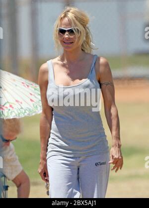 Pamela Anderson seduta sull'erba, mangiando hamburger a Malibu, CA maggio 2008 Foto Stock
