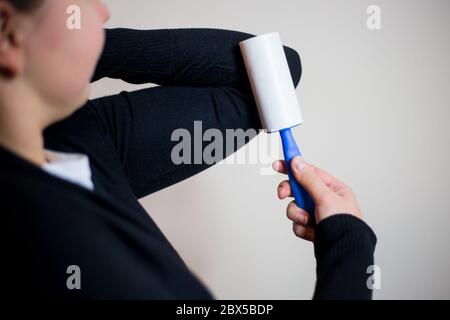 Donna piuttosto giovane bruna che usa il rullo per il suo ponticello nero, usando il rullo per la cattura delle impurità Foto Stock