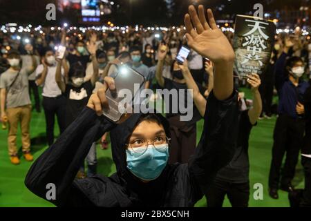 Un uomo si fa un gesto durante la veglia di Piazza Tiananmen al Victoria Park di Causeway Bay, Hong Kong, il 04 giugno 2020. Migliaia di persone in tutta Hong Kong si sono riunite e accese candele il 4 giugno per commemorare il massacro di Tiananmen nonostante il divieto del governo contro le riunioni. Foto Stock