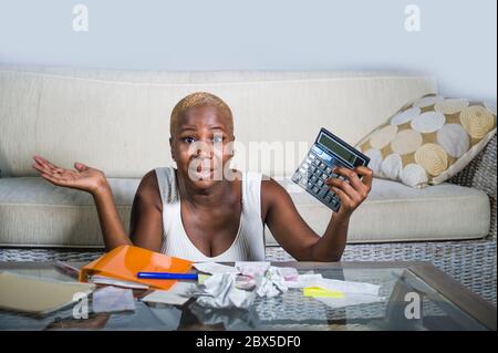 Donna afro americana nera disperata e stressata con calcolatore e cartwork banking in stress contabilità business finanza fiscale e pagamenti in finan Foto Stock