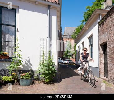 donna in bicicletta per le strade della vecchia zutphen nei paesi bassi Foto Stock
