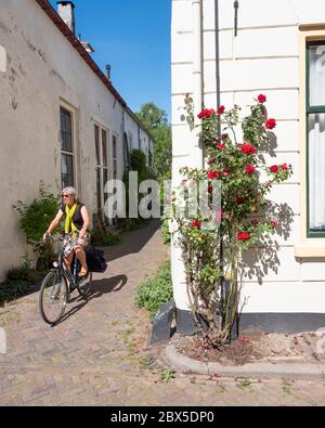 donna in bicicletta per le strade della vecchia zutphen nei paesi bassi Foto Stock