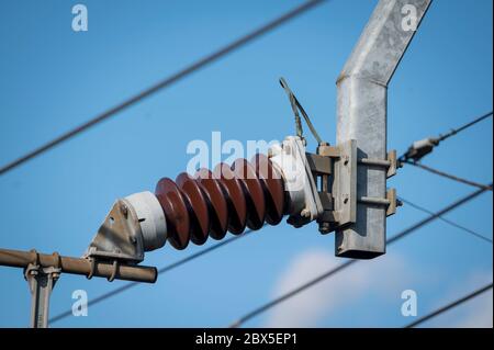 Isolante in ceramica e catenaria su una linea ferroviaria elettrificata nel Regno Unito. Foto Stock