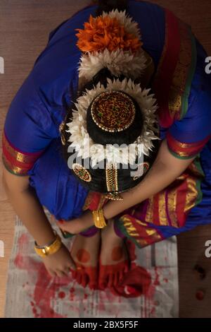 Ballerina di Bharatnatyam che applica alta sui suoi piedi. Foto Stock