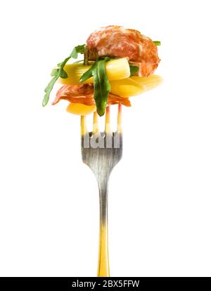 insalata italiana con pasta, foglie di rucola e fetta di salame appiccicate su una forchetta d'argento, isolata su sfondo bianco Foto Stock
