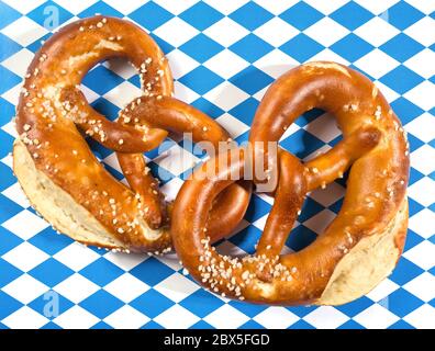 due pretzel bavaresi su stampa di bandiera bavarese bianca e blu Foto Stock