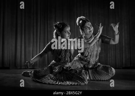 Immagine in bianco e nero di una ballerina bharatnatyam che insegna al suo giovane studente. Foto Stock