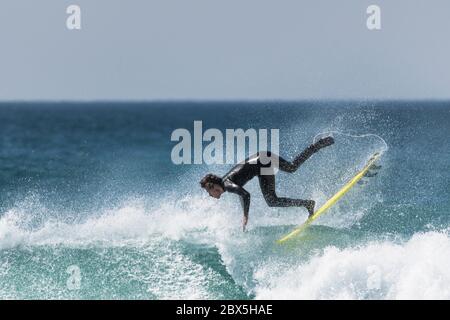 Azione spettacolare mentre un giovane surfista si stanca a Fistral a Newquay in Cornovaglia. Foto Stock